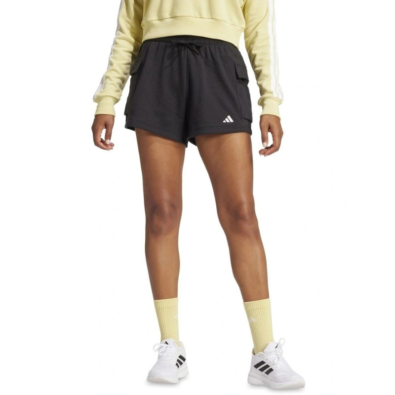 Person wearing black Adidas shorts and a light yellow sweatshirt on a white background