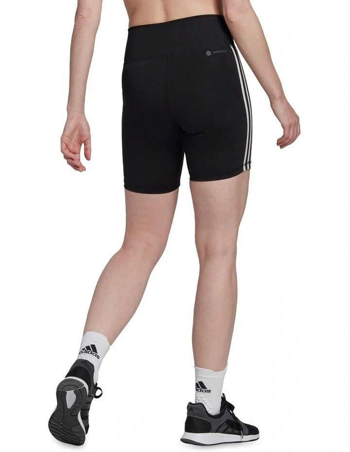 Person wearing black Adidas shorts with white stripes on a white background