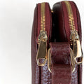 Red leather women’s shoulder bag with three compartments, elegant small satchel design featuring adjustable strap and gold hardware.
