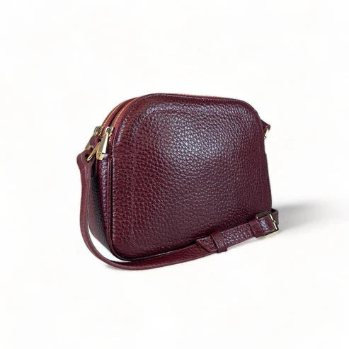 Red leather women’s shoulder bag with three compartments, elegant small satchel design featuring adjustable strap and gold hardware.