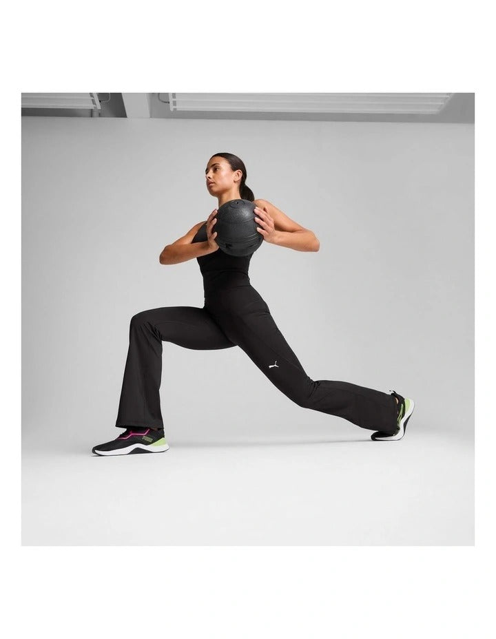 Person wearing black athletic pants with a visible brand logo on a gray background