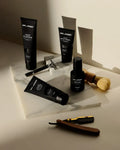Virtue men’s skincare set with cleanser, exfoliator, moisturizer, face mask, and serum in sleek black packaging displayed with male models