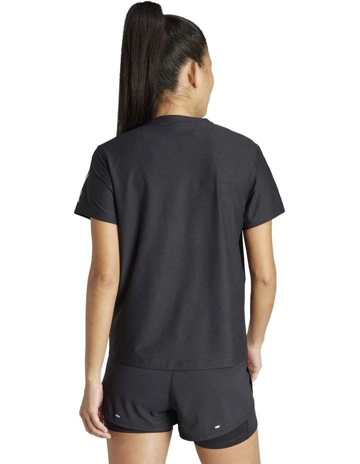 Woman wearing a black Adidas athletic outfit on a white background