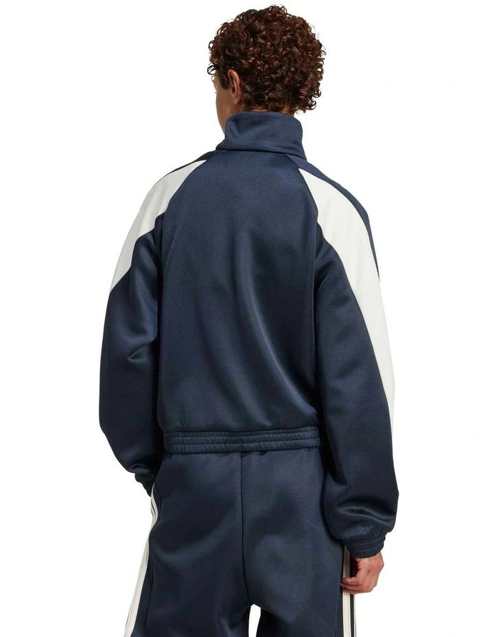 Person wearing a navy tracksuit with white sleeves on a white background