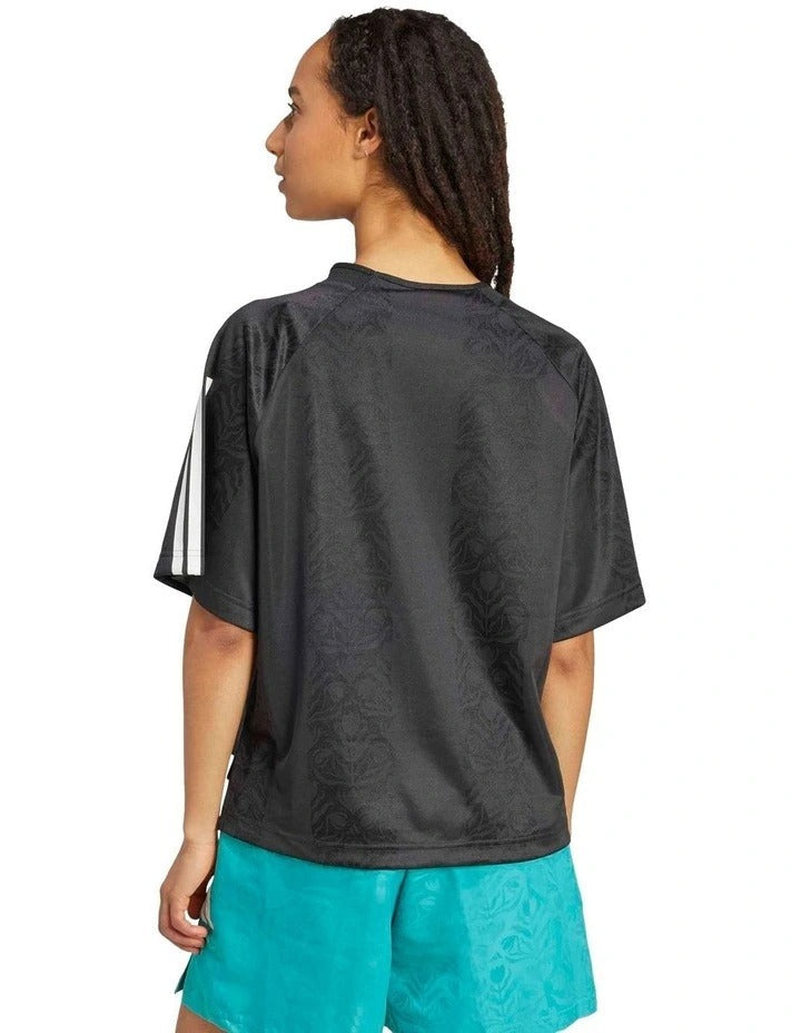 Person wearing a black Adidas Sportswear t-shirt on a white background