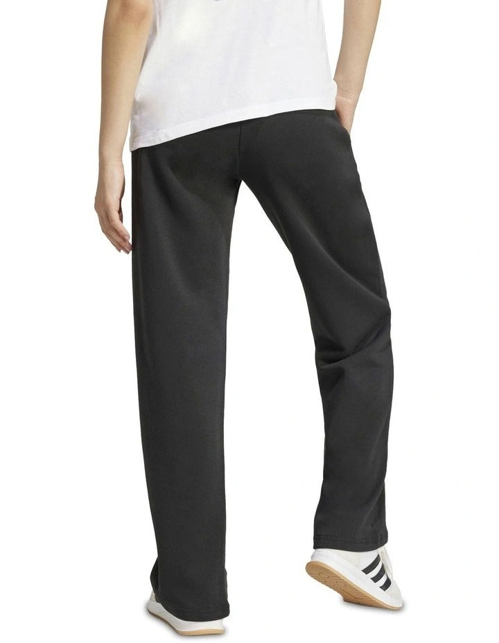 Person wearing black Adidas pants on a white background