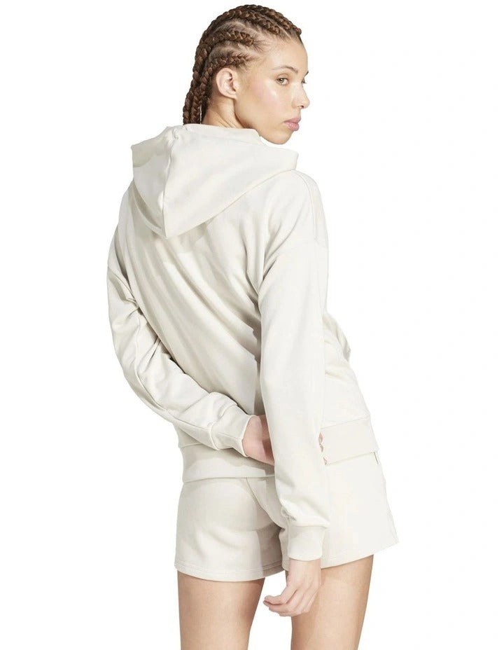 Woman wearing a beige hoodie and shorts on a white background