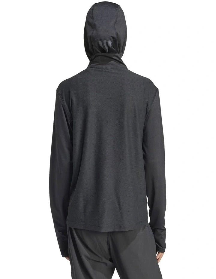 Person wearing a black Adidas hoodie and shorts on a white background
