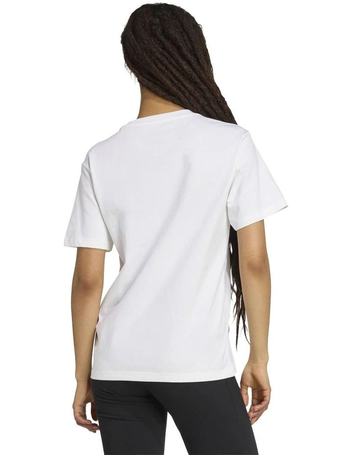 Person wearing a white t-shirt with pink graphics on a white background